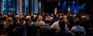 Taler på scenen foran et siddende publikum ved et fagligt arrangement